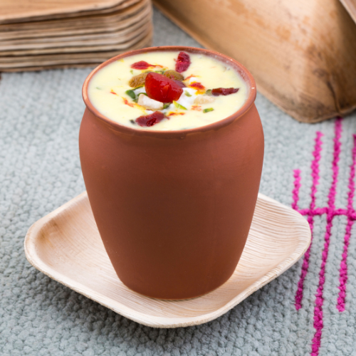 Chilled summer lassi in clay glass with mint garnish - Nutriworld